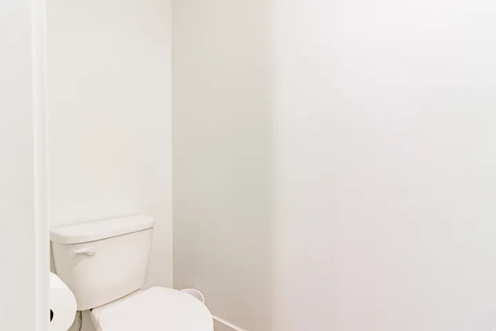 White toilet with a round bowl and exposed plumbing