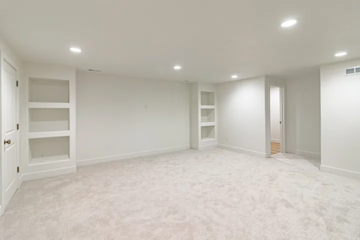 Recessed lighting, light-toned carpet, built-in shelving, white walls, and white trim