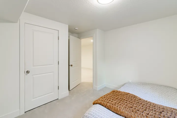 Bright secondary bedroom featuring neutral wall finishes, carpeted flooring, and direct access to hallway