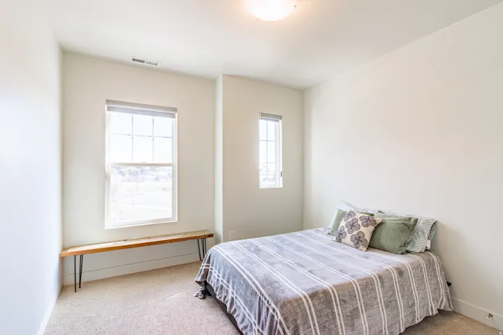 Wall-to-wall carpeting, two separate windows, and a flush-mount ceiling light