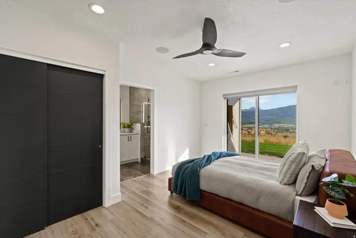 Wood-finish flooring, sliding glass door, recessed lighting, ceiling fan, and sliding closet doors