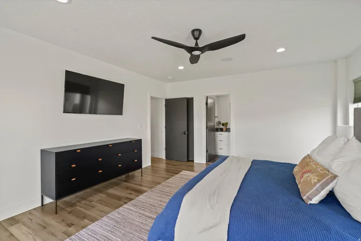 Wood-finish flooring, recessed lighting, and a contemporary ceiling fan