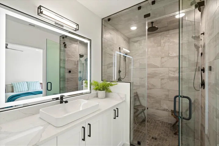 Modern primary bathroom featuring a floating vanity with a rectangular vessel sink, quartz countertop, and matte black fixtures
