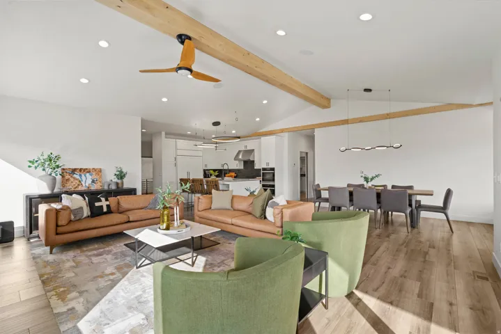 Vaulted ceilings with exposed wood beams, recessed lighting, wood-finish flooring, and a modern linear dining fixture