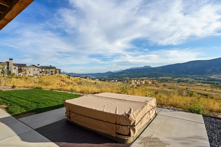 Expansive outdoor patio featuring a hot tub, concrete paving, and composite decking