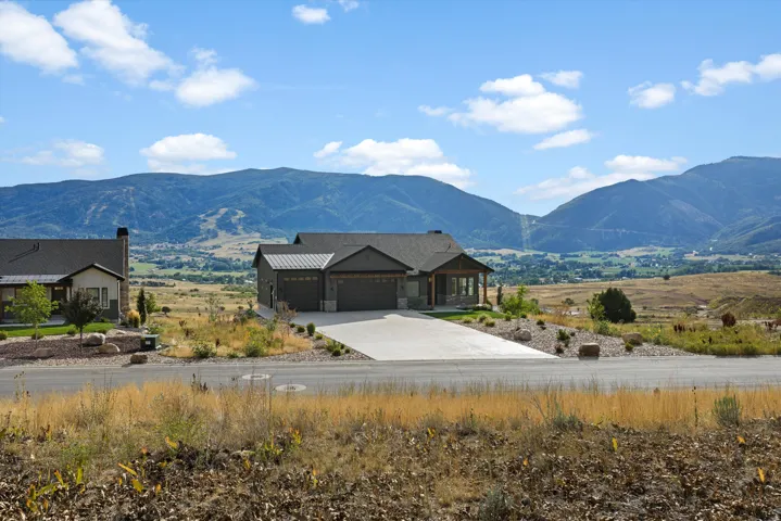 Ranch-style exterior with a covered porch entry, a two-car garage, and a concrete driveway