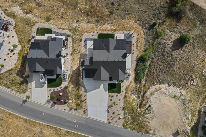 Contemporary residences with dark shingle roofing, concrete driveways, and manicured landscaping