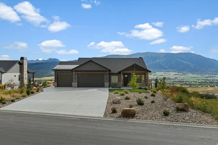 Exterior featuring a two-car garage, stone accents, and a covered front entry