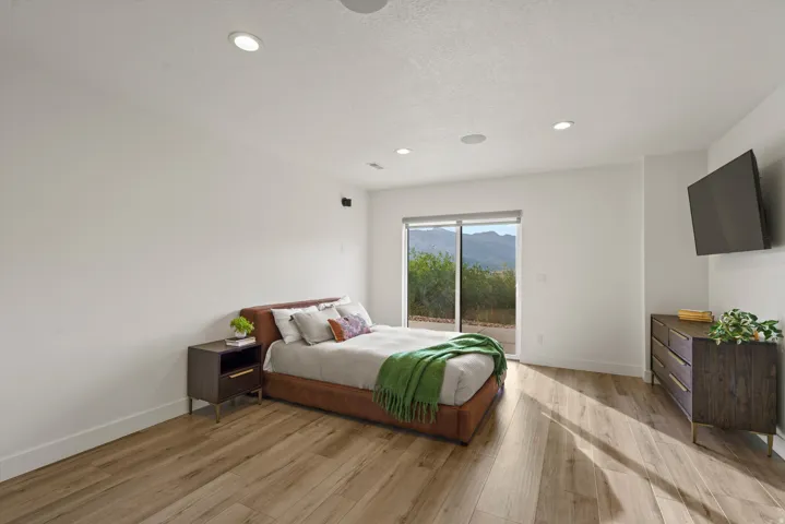 Wood-finish flooring, recessed lighting, built-in ceiling speakers, sliding glass door, and mountain scenery