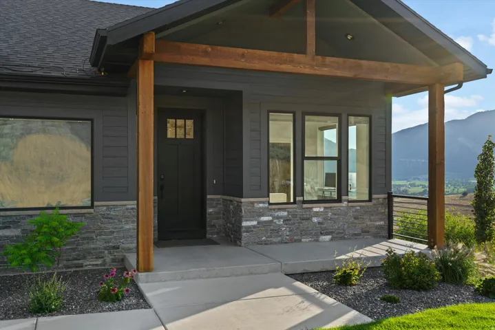 Covered front entry featuring wood pillars and stone accents