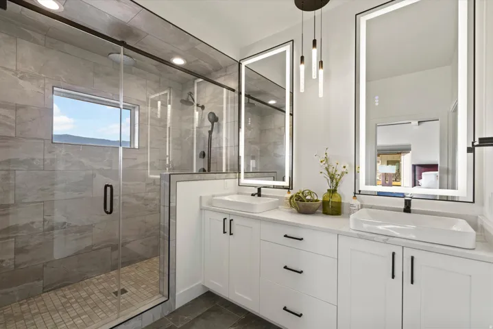 Dual vanity with vessel sinks, white cabinetry, and matte black hardware