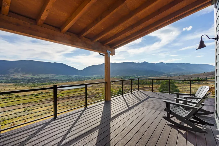 Expansive outdoor deck with composite decking, cable railing, and a vaulted wood-finish ceiling
