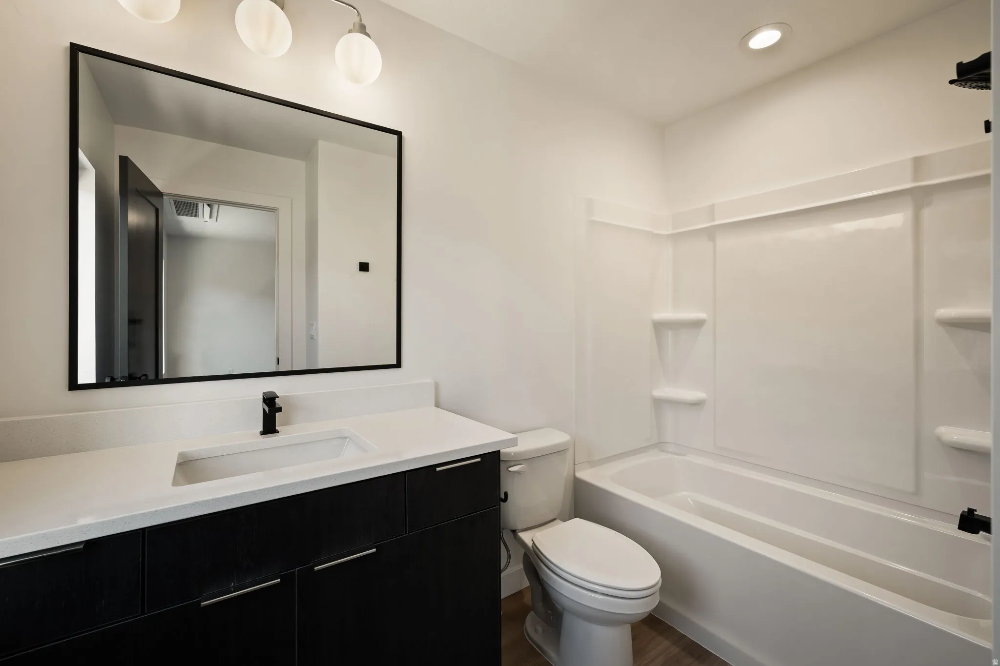 Modern vanity with a white countertop and dark cabinetry
