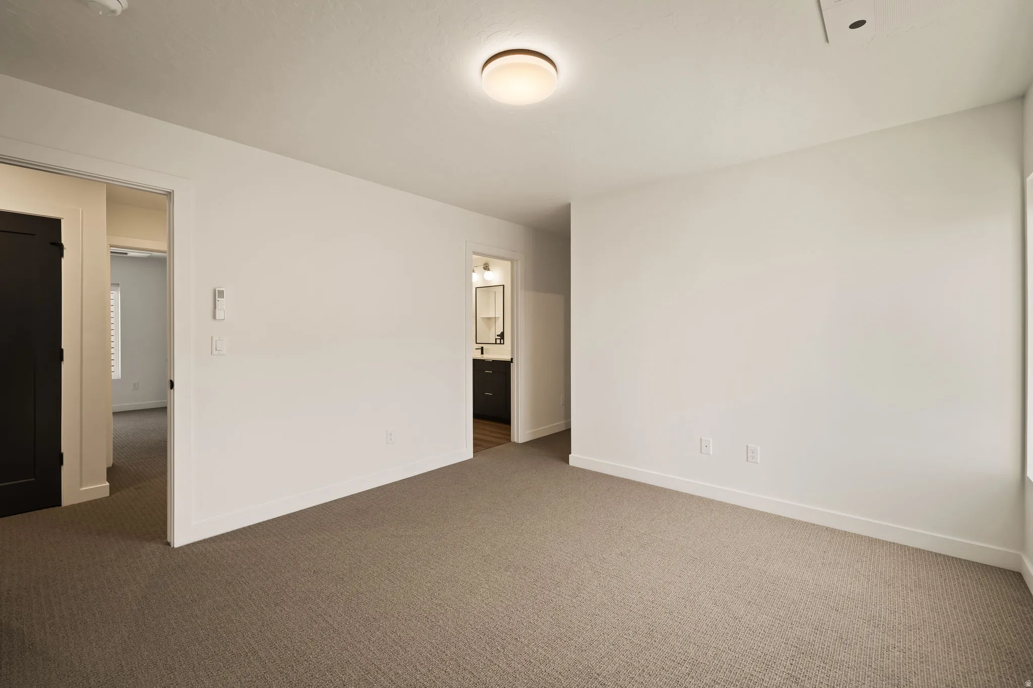 Carpeted flooring throughout, recessed lighting, and a modern ceiling light fixture