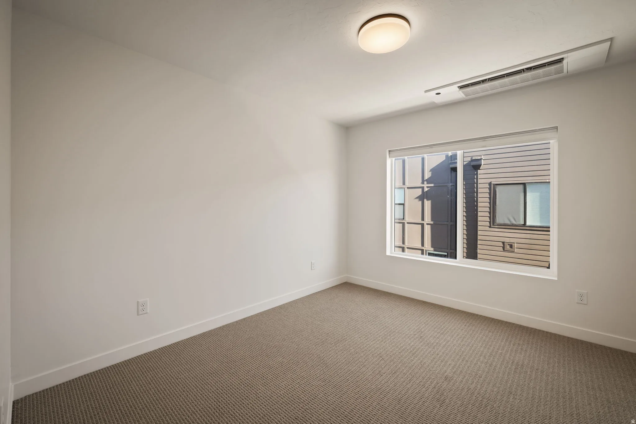 Recessed lighting, neutral wall tones, carpeted flooring, and a large window