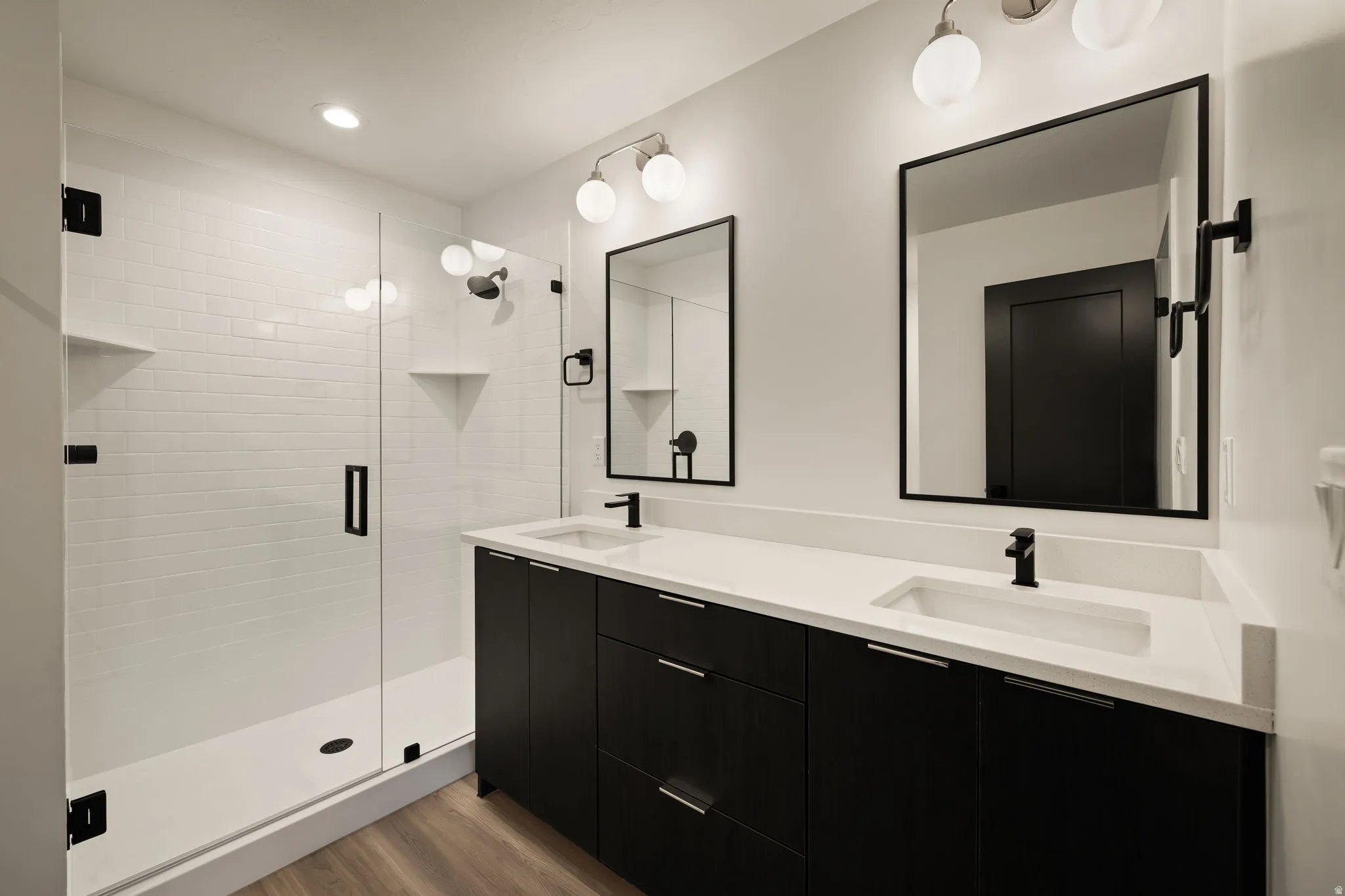 Double vanity with integrated sinks, white countertops, and matte black fixtures