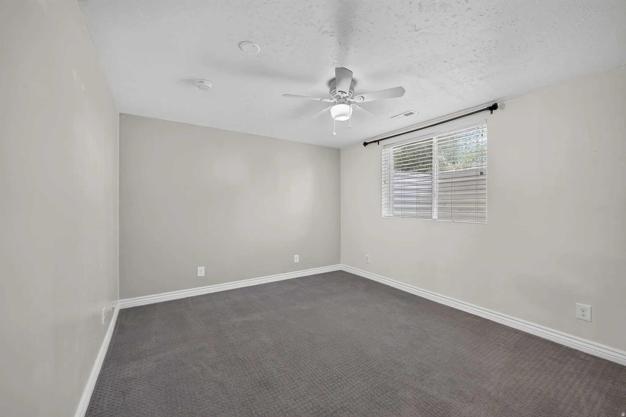 Gray wall-to-wall carpeting with white baseboards