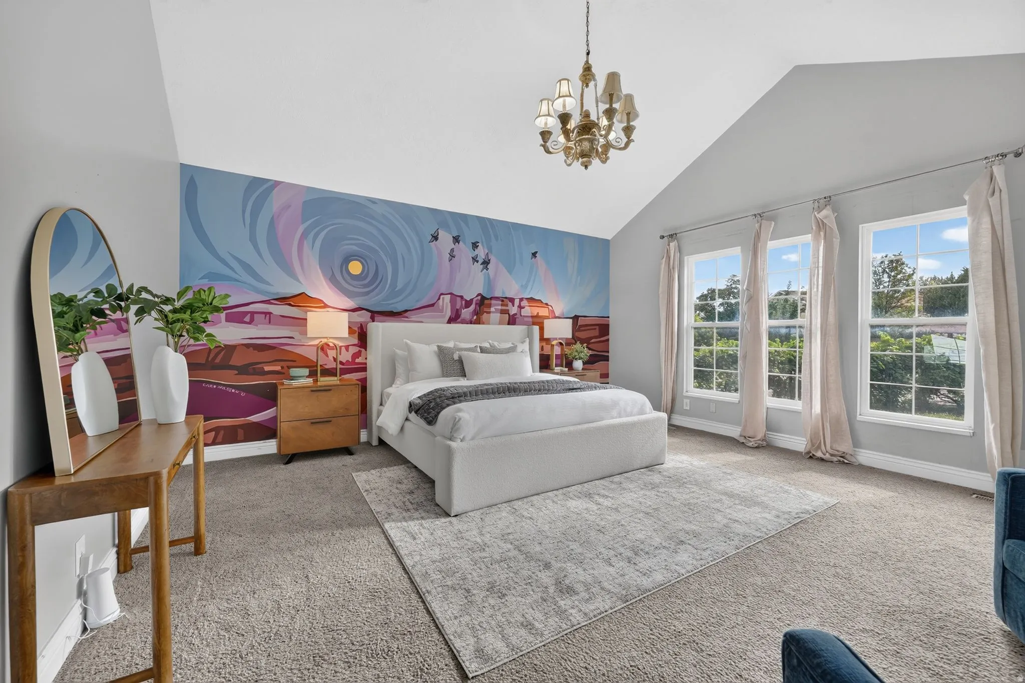 Vaulted ceiling with a chandelier, three large windows, and a decorative mural wall
