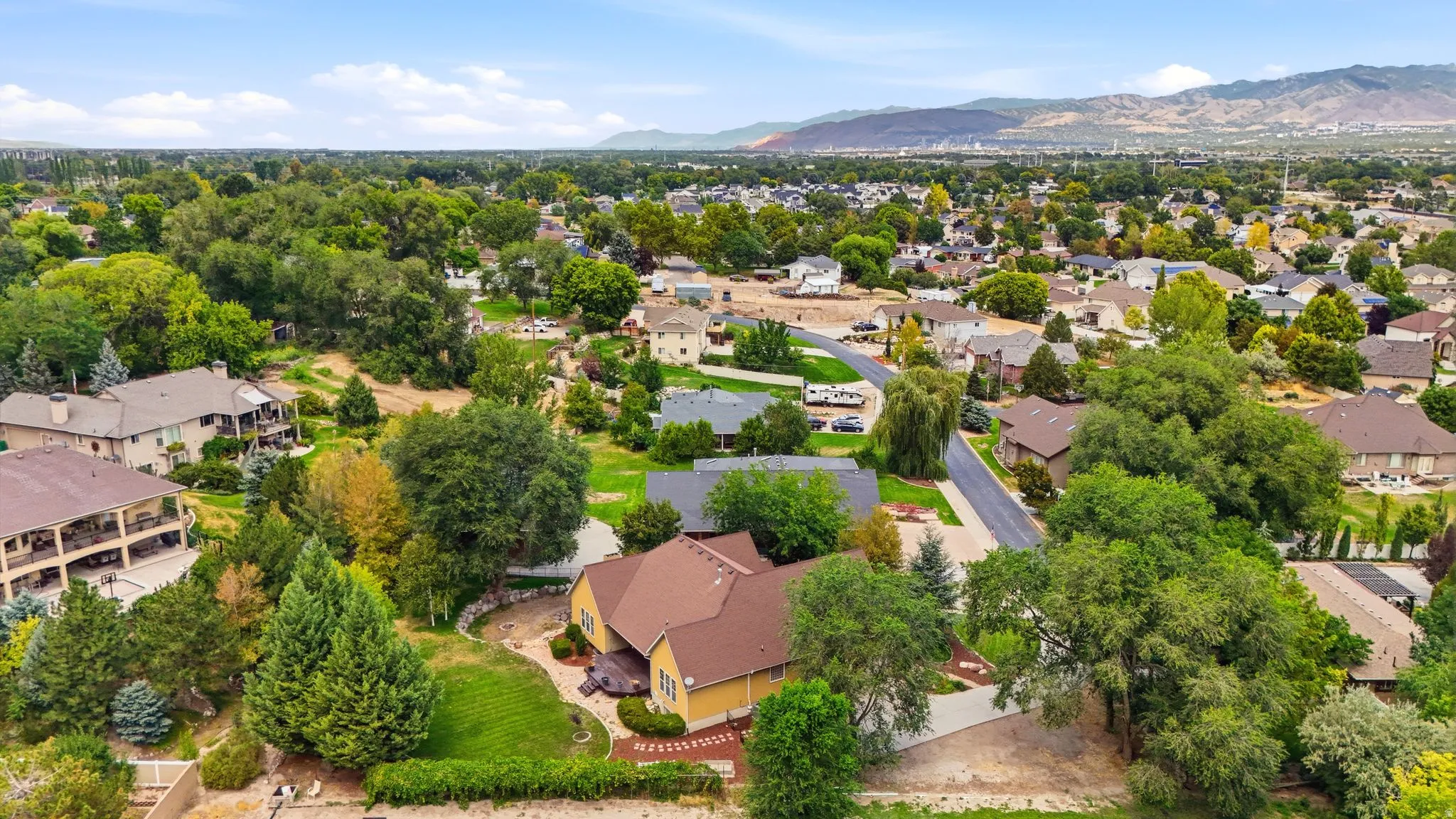 Expansive residential property with mature landscaping and mountain backdrop