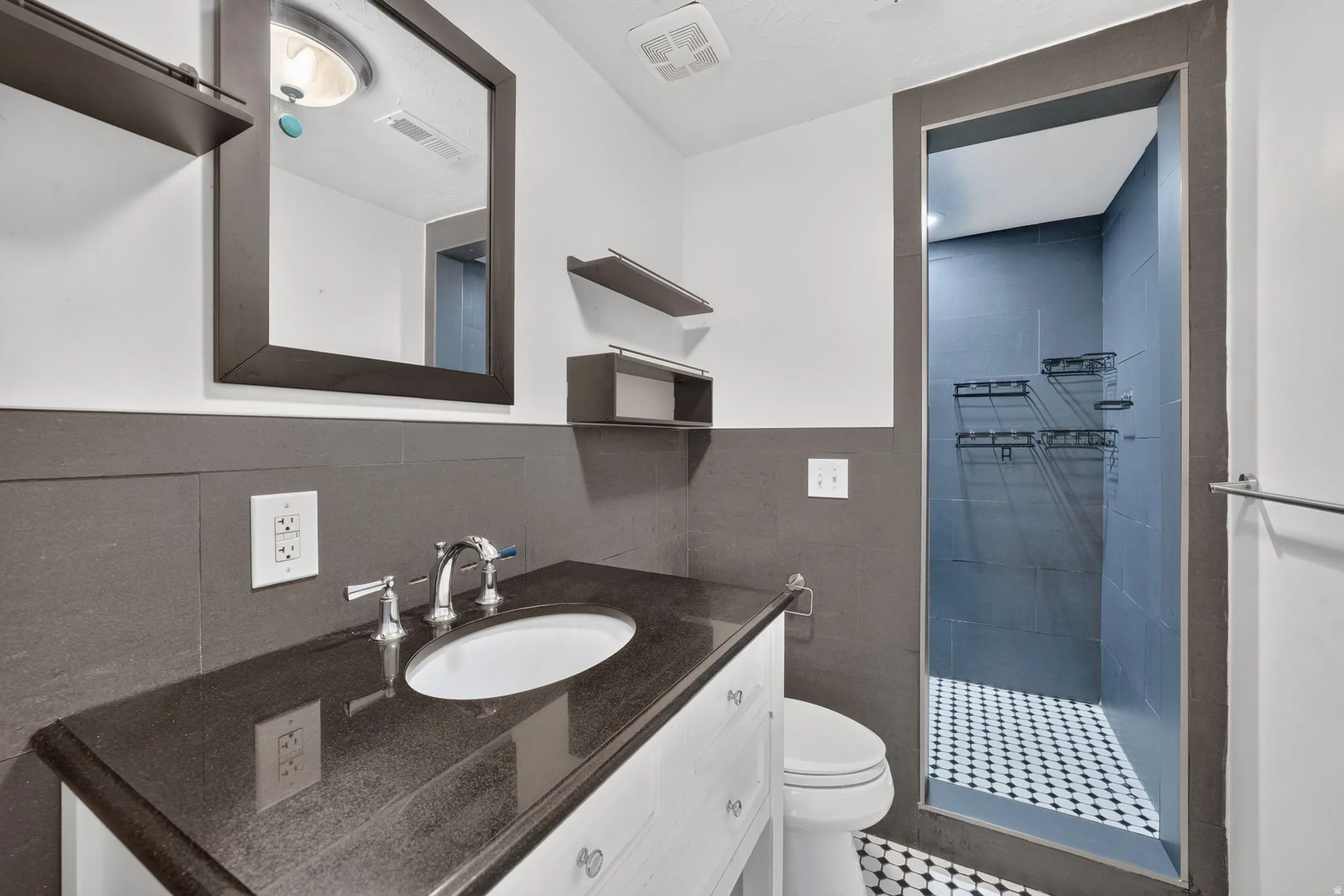 Vanity with integrated sink, polished chrome faucet, and dark countertop