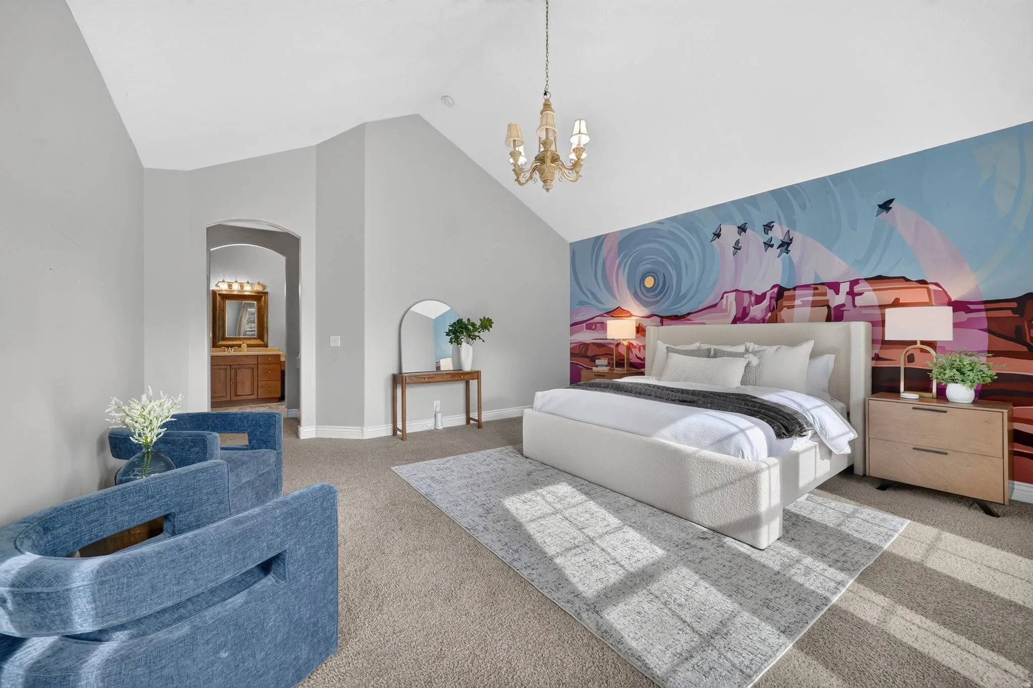 Vaulted ceiling with an ornate chandelier, carpet flooring, arched doorway, and an accent wall