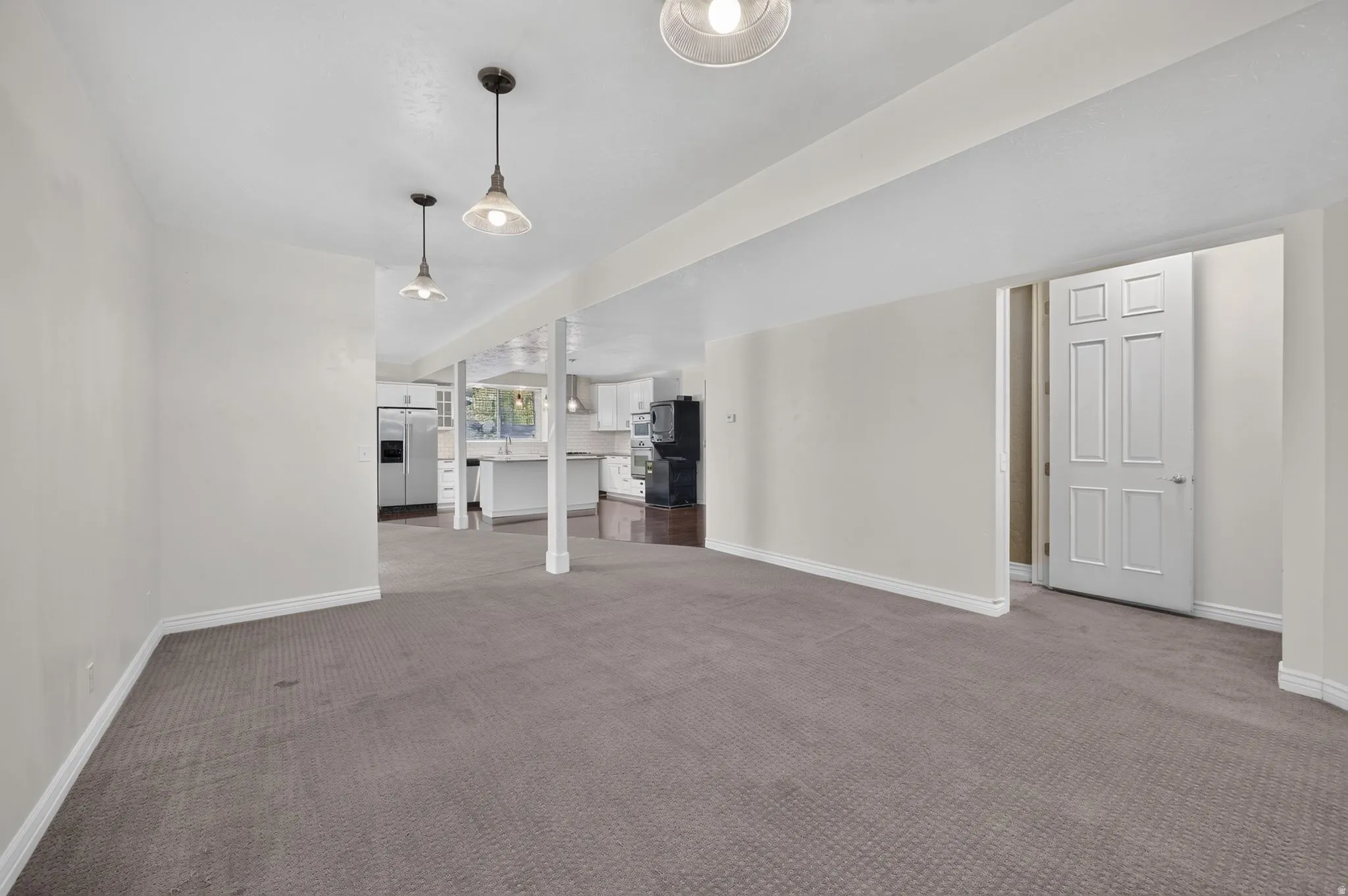 Spacious room featuring neutral carpet and white trim