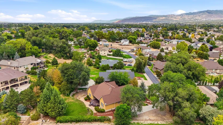 Expansive residential property with mature landscaping and mountain backdrop