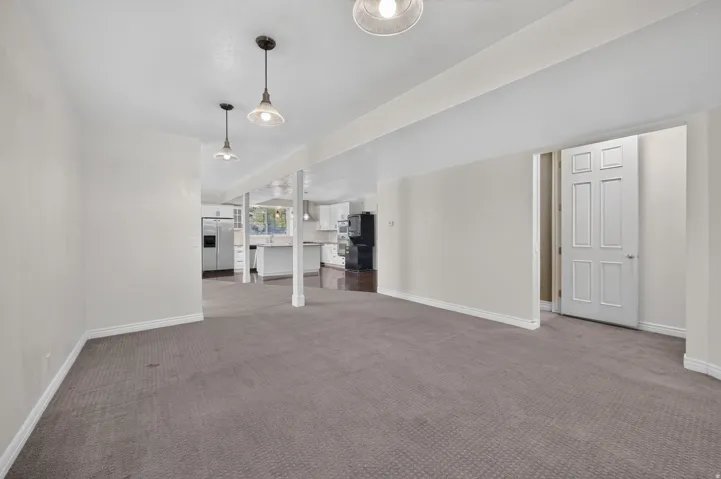 Spacious room featuring neutral carpet and white trim