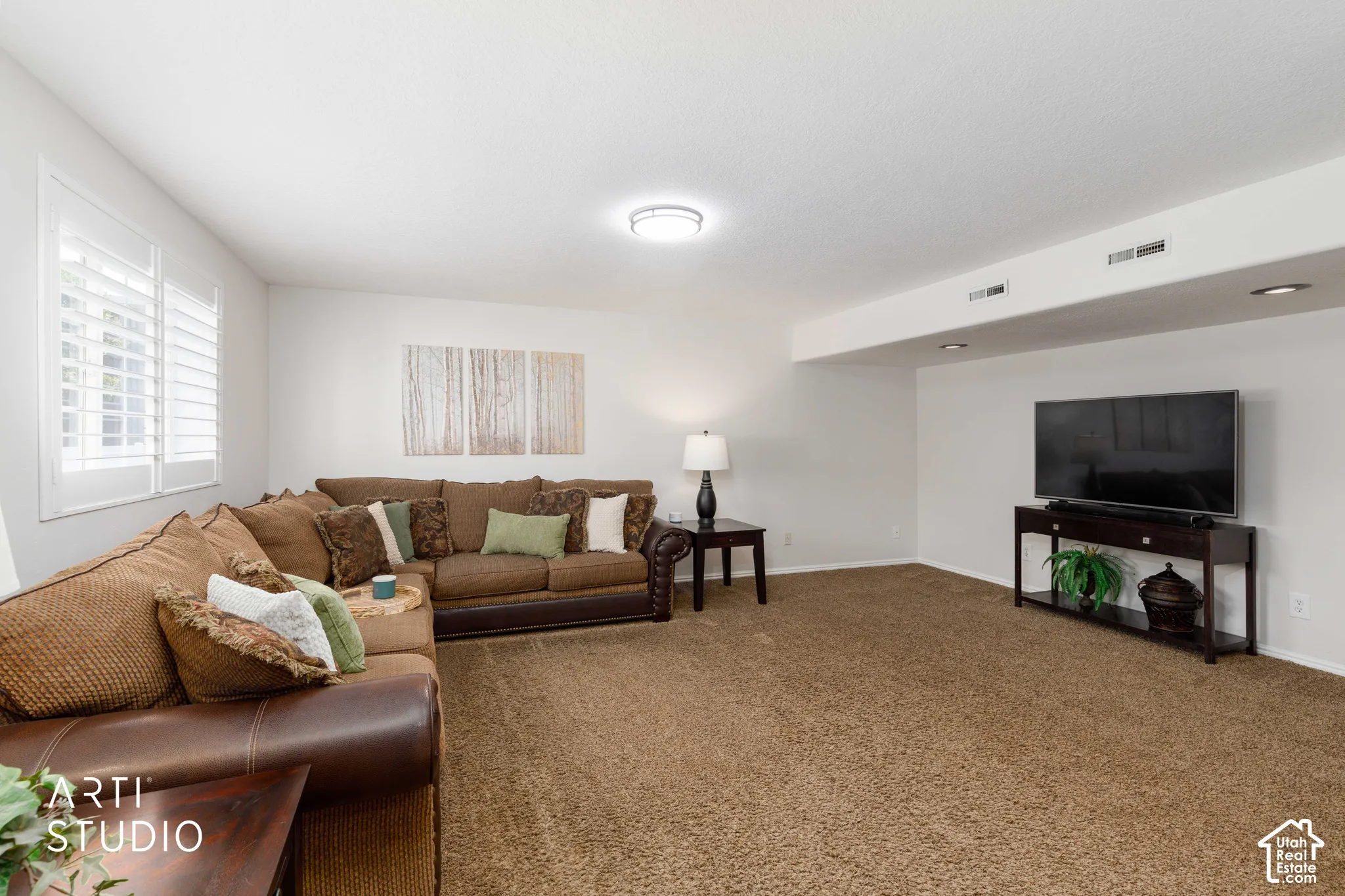 Main Basement Family room with recessed  and new flush mount, matte black lighting, white walls, and professionally cleaned brown carpeting