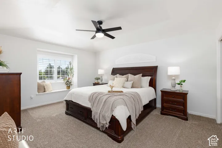 Bedroom #3 (Primary) Includes a recessed window with white plantation shutters, white plantation black out fan over half moon shaped Window located over bed.