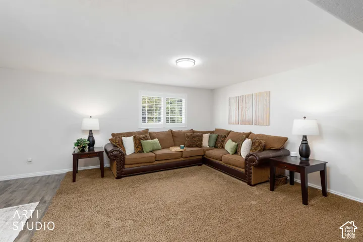 White walls, window with white Plantation shutters, Pergo wood-finish flooring, brown carpet, and overhead flush mount modern ighting.