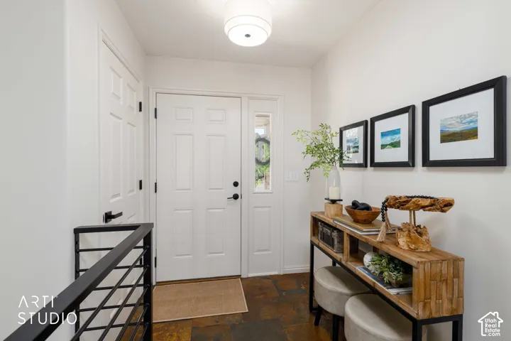 Entryway featuring durable slate flooring and a contemporary pendant light fixture and new metal railing