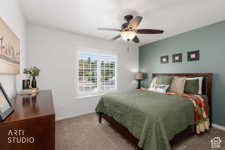 Bedroom #2 Ceiling fan with integrated lighting, window with plantation shutters, a contrasting  green accent wall and new tan carpet