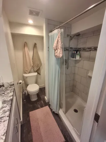 Walk-in shower with tile surround, decorative accent tile, and built-in shelving