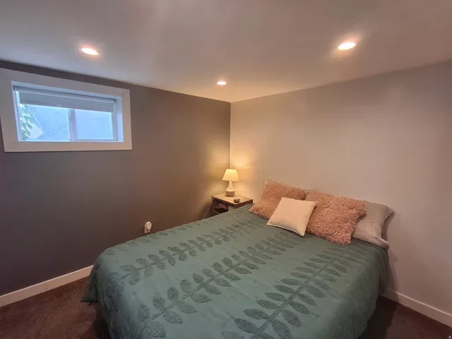 Recessed lighting, two-tone wall paint, and a window with white trim