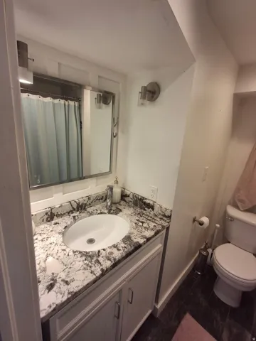Vanity with granite-style countertop, undermount sink, and brushed nickel fixtures