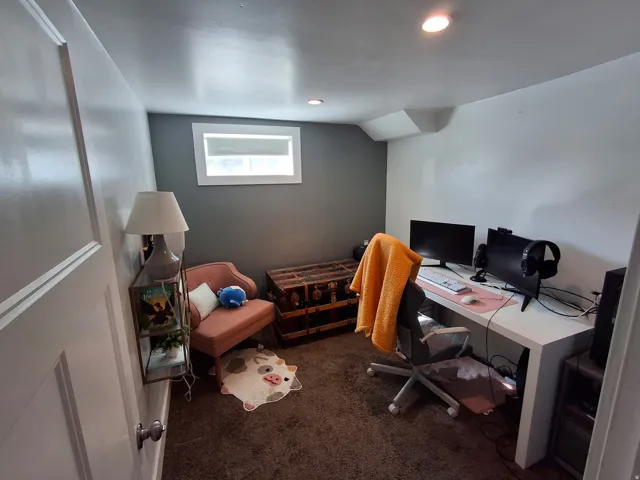 Recessed ceiling lighting, a window with blind, and a white paneled door