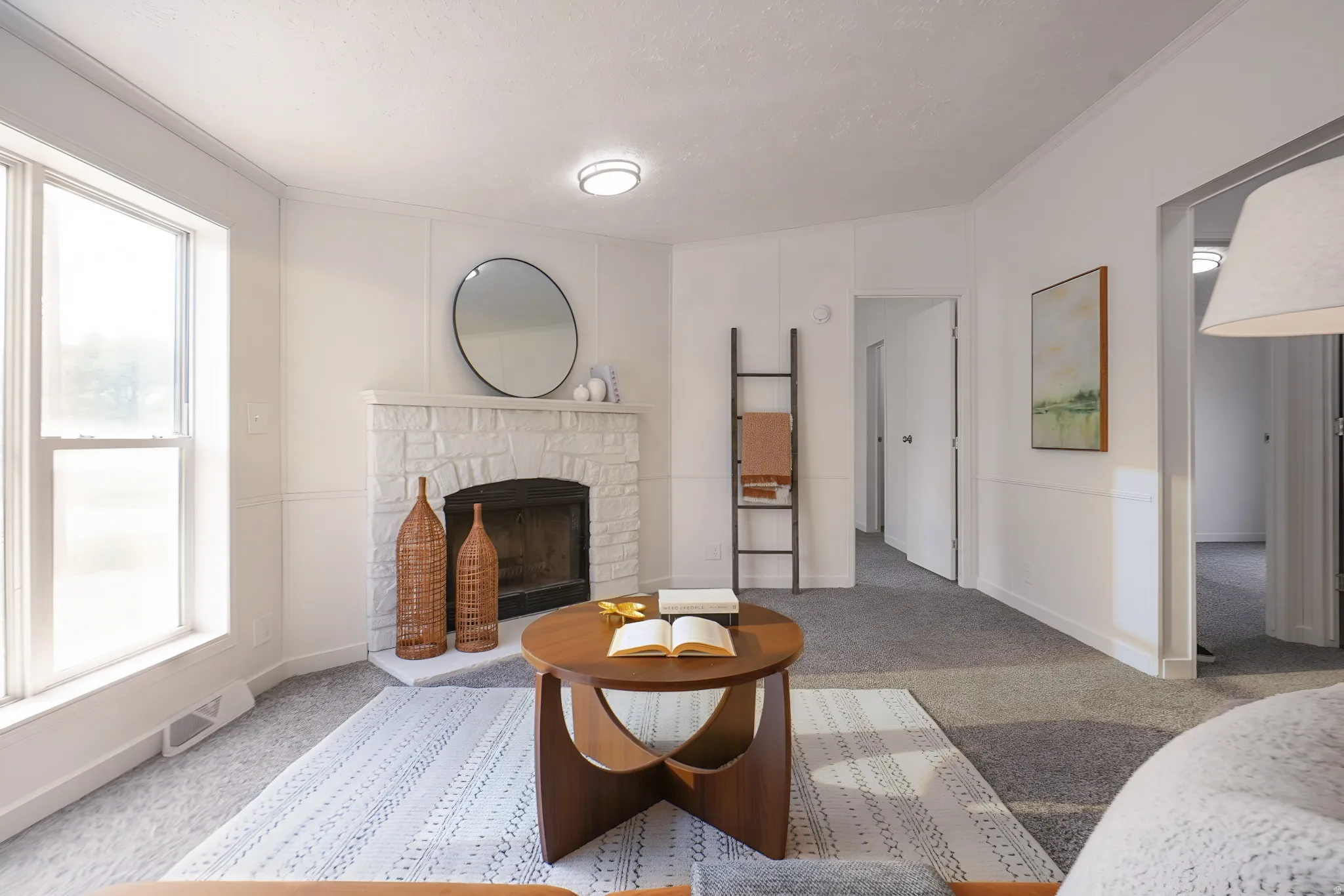 Living area featuring a stone-clad fireplace, large picture window, wall paneling, and neutral carpeting