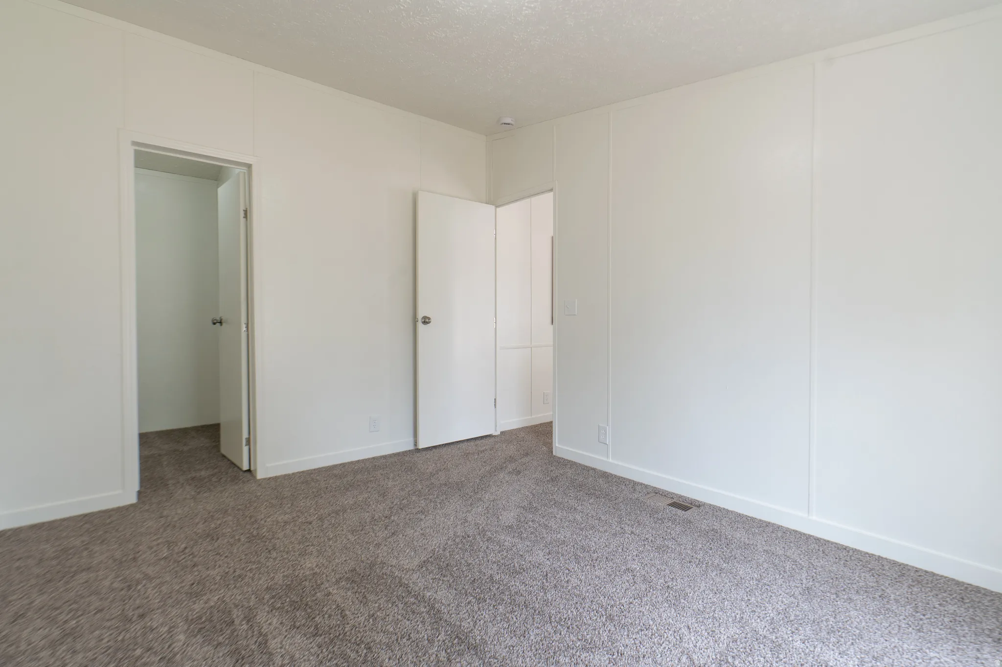 Plush carpeting, neutral wall finishes, and white interior doors