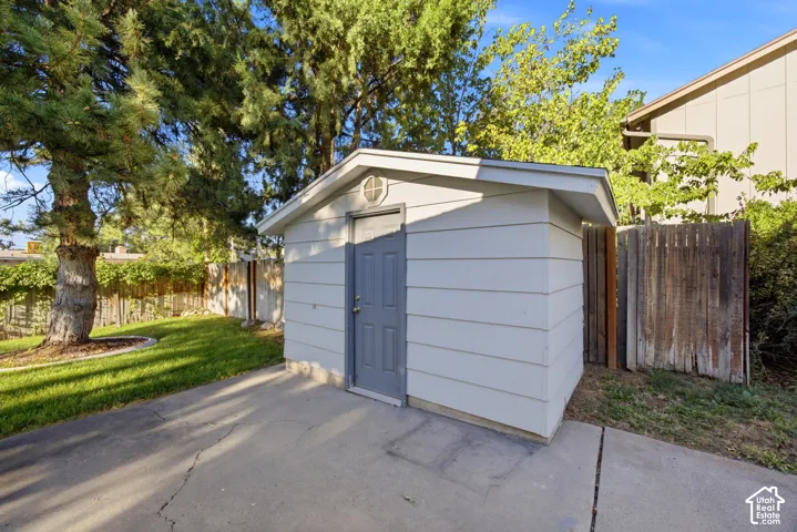 Exterior storage shed with siding, a paneled door, and a circular accent window