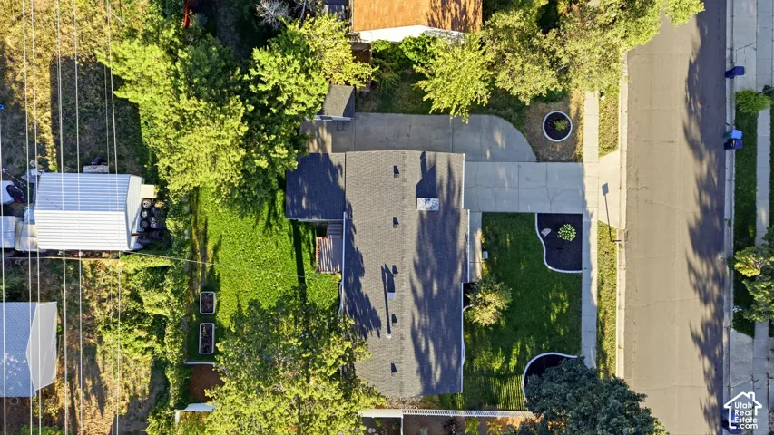 Asphalt shingle roof, concrete driveway, and established landscaping