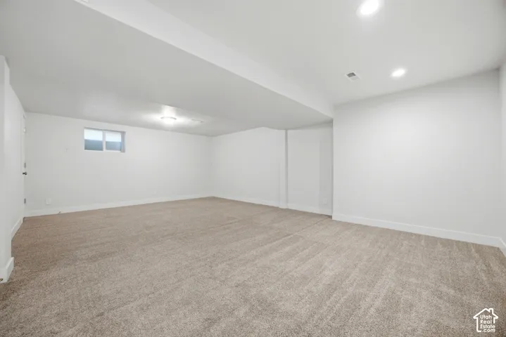Spacious room with plush carpeting, recessed ceiling lighting, and a single window
