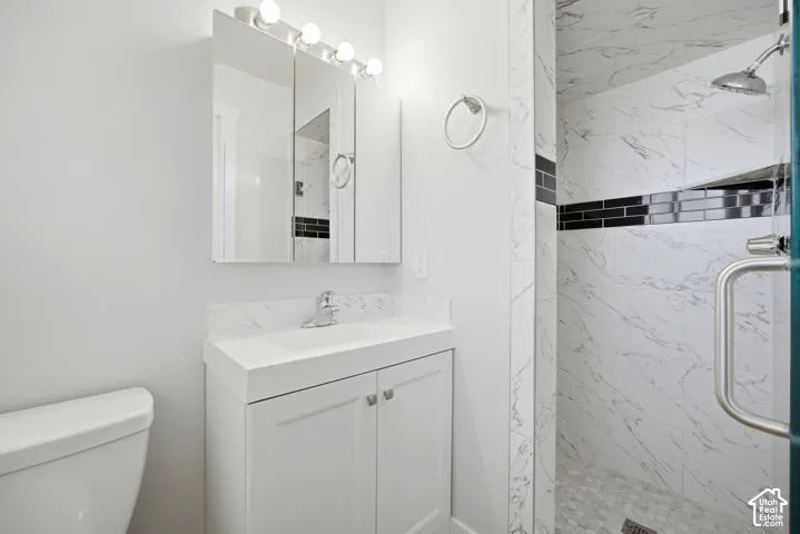 White vanity with integrated sink, chrome faucet, and mirrored medicine cabinet