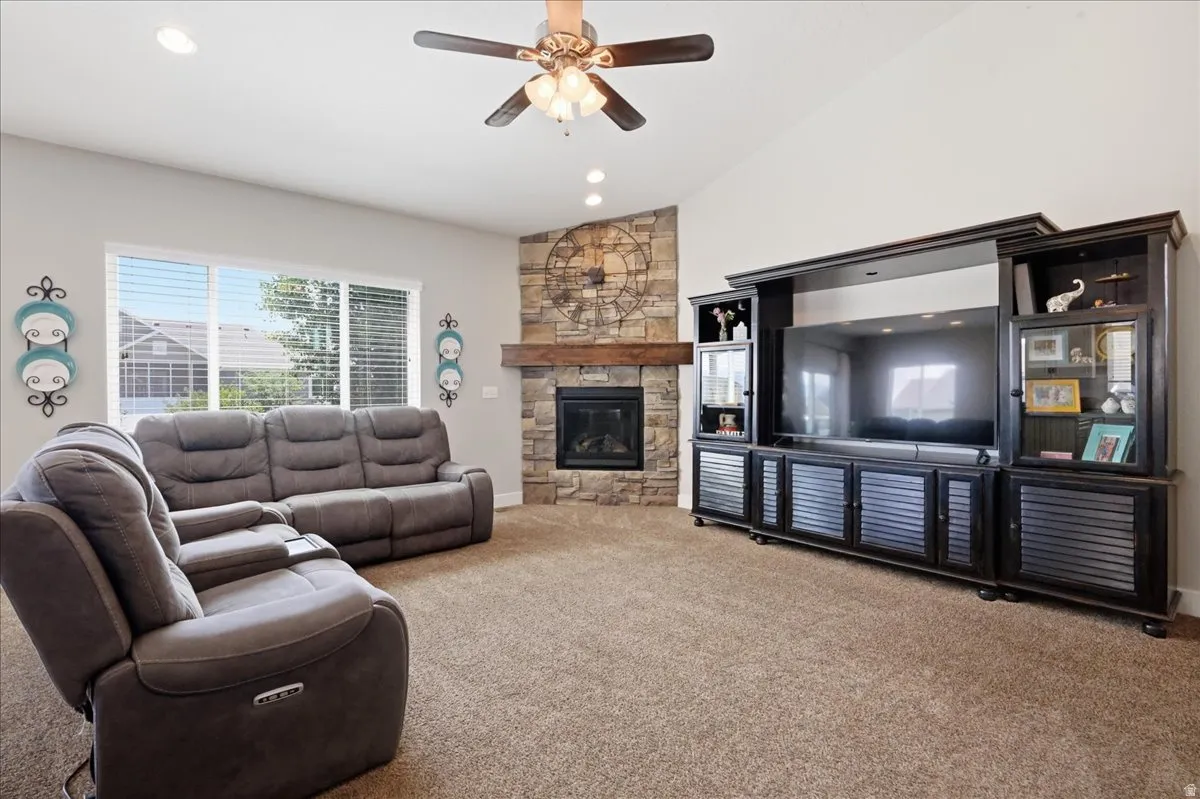 Vaulted ceiling with recessed lighting, ceiling fan, and large windows