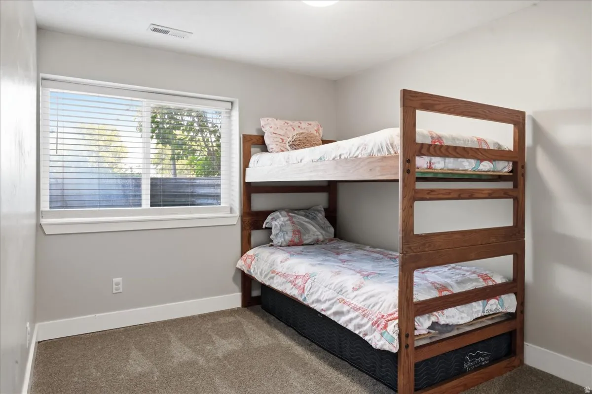 Neutral-toned walls, a white-framed window, and carpeting