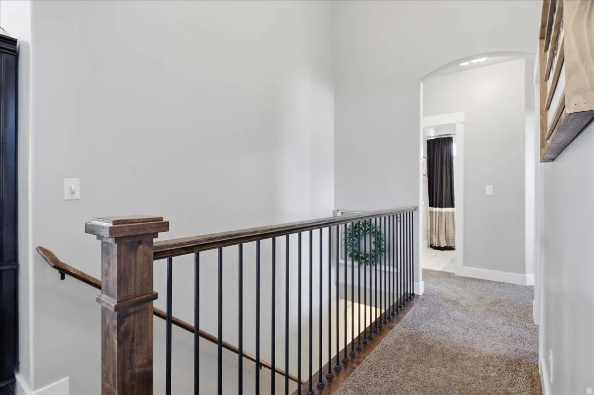 Staircase featuring wood newel posts and handrail with black metal balusters