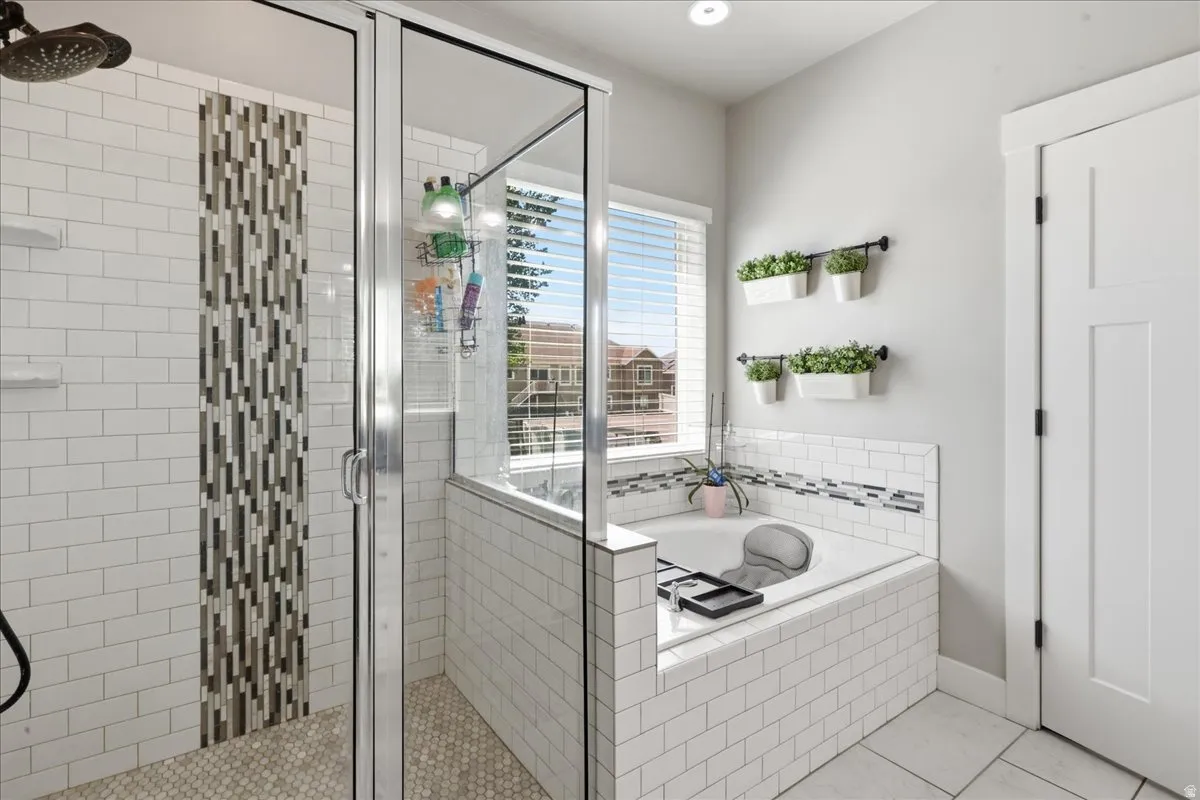 Shower with glass enclosure, subway tile surround, and mosaic tile accent