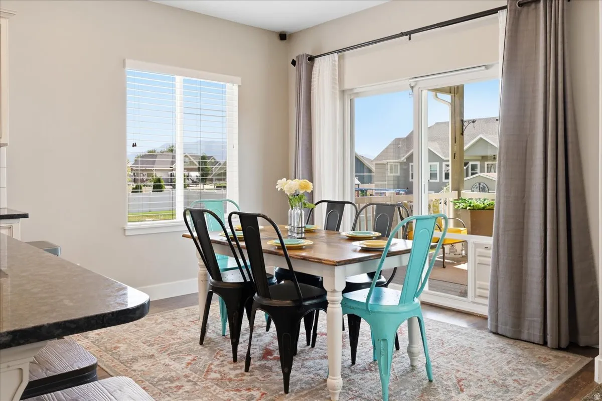 Dining area featuring a sliding glass door, a window with blinds, and wood-finish flooring