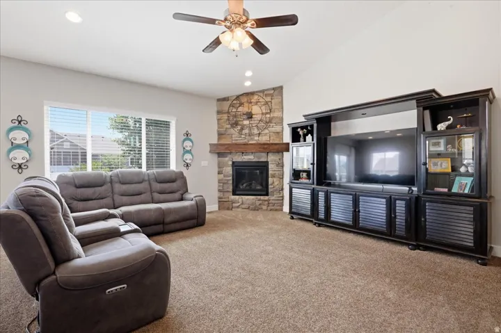 Vaulted ceiling with recessed lighting, ceiling fan, and large windows