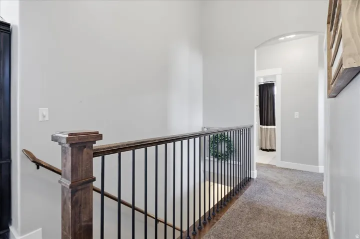 Staircase featuring wood newel posts and handrail with black metal balusters